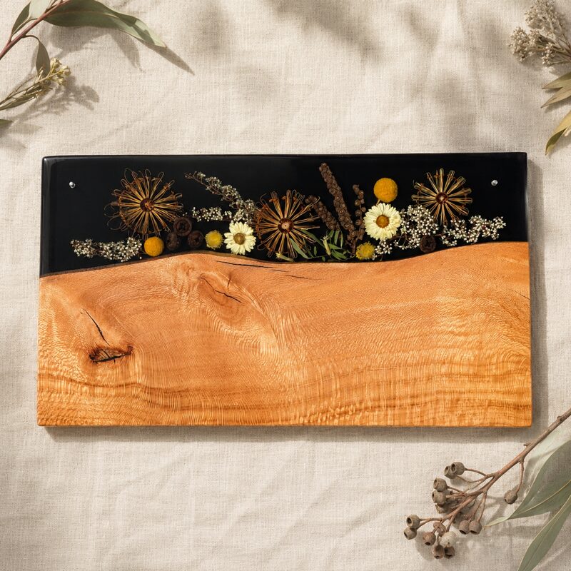 Handmade Australian timber and black resin serving platter featuring preserved native wildflowers and richly figured golden timber.