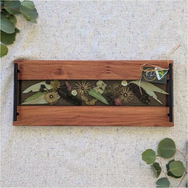 Celebrate her special day with a gift as enchanting and unique as she is. Our Handcrafted Timber, Resin, and Australian Floral Grazing Board is the perfect luxury gift for the bride on her wedding day, meticulously crafted to capture the essence of natural beauty. Each board is a stunning amalgamation of hand-selected Australian timber and vibrant native flora delicately preserved in resin. This one-of-a-kind piece serves not only as a functional serving board but also as a work of art that will adorn her home for years to come. Imagine the joy on her face as she unwraps this exquisite creation, a testament to your love and admiration for her. Whether used to showcase gourmet cheeses, charcuterie, or decadent desserts, this board enhances any culinary display with its unique blend of elegance and natural charm. Order now to secure this exceptional piece and give her a wedding day gift she will forever cherish.
