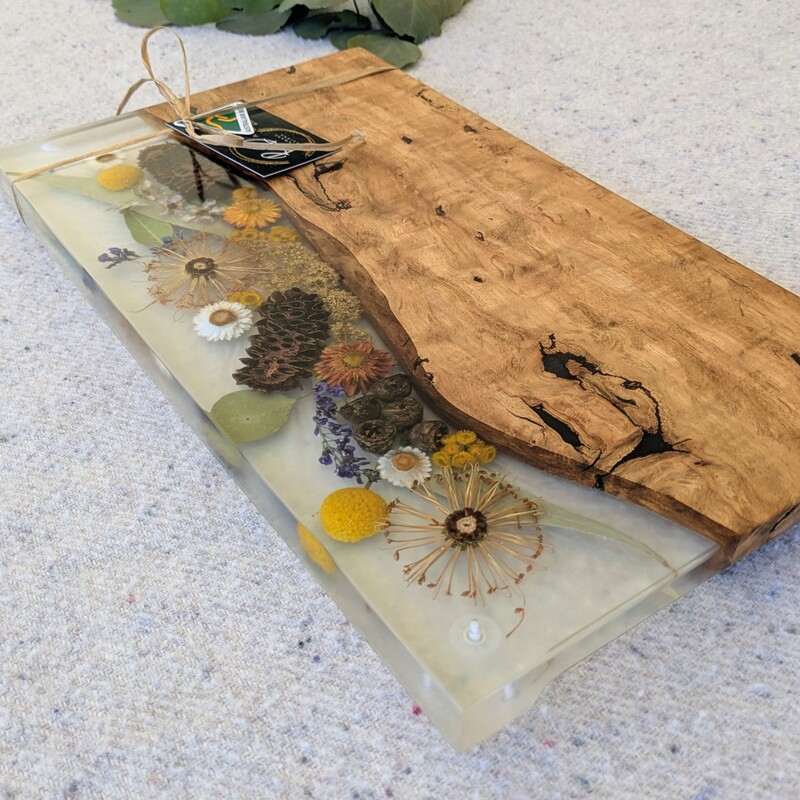 Elevate your home or gift-giving experience with our 100% Australian-made handcrafted serving board, a masterpiece of timber, resin, and dried native flora. Each board is meticulously crafted to not only serve as a functional piece but also as a captivating storyteller of the Australian bush. Experience the charm and craftsmanship of our 100% Australian-made serving board today. Order now and bring home a piece of the Australian bush that tells a story of artistry, sustainability, and natural beauty.