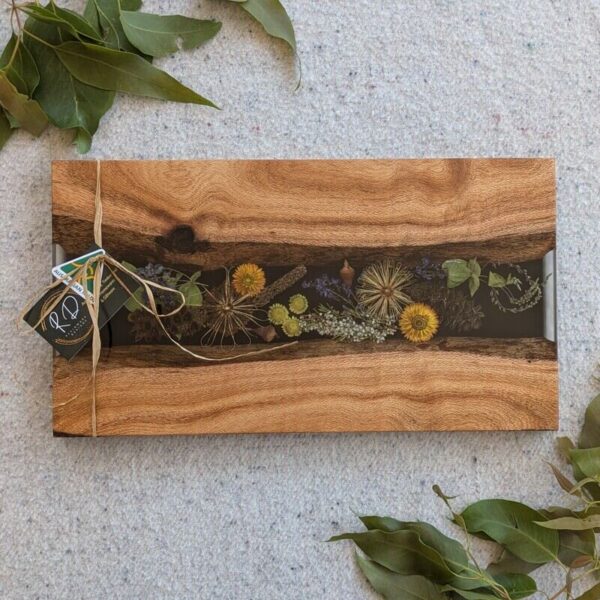 Celebrate Australia with our handcrafted serving platter. Made from locally sourced timber, resin, and dried Australian flora, it serves as a functional cheese board and a showcase of Australia’s beauty. Perfect for gifting, each board blends native timber with translucent resin and preserved flora, capturing the essence of our landscapes.