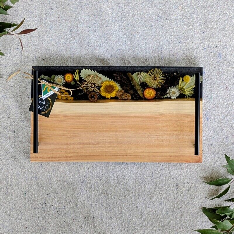 Celebrate Australia with our handcrafted serving platter. Made from locally sourced timber, resin, and dried Australian flora, it serves as a functional cheese board and a showcase of Australia’s beauty. Perfect for gifting, each board blends native timber with translucent resin and preserved flora, capturing the essence of our landscapes. Presented in elegant packaging, it’s a thoughtful gift ready for worldwide shipping.