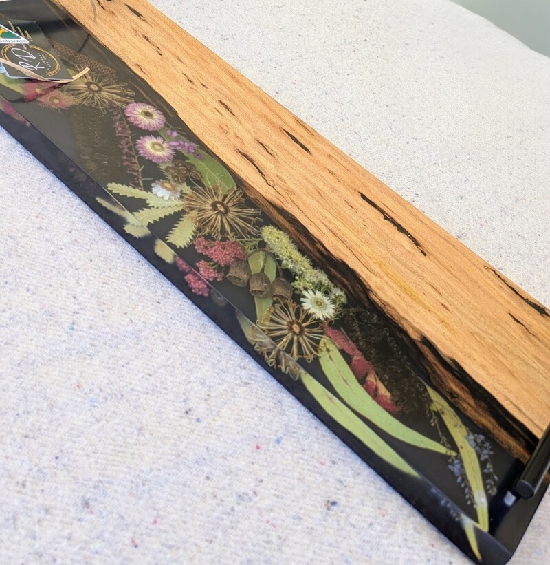 Discover the beauty of Australia’s landscapes in a functional piece of art with our unique cheese board. Made from locally sourced timber, resin, and dried Australian flora, each board is a testament to artisanal craftsmanship and the natural splendor of our continent. Designed to elevate your home decor, our cheese boards are not just serving essentials but exquisite pieces that showcase Australia’s stunning flora. Each board features carefully arranged dried native flora encased in translucent resin, creating a mesmerizing display of colors and textures. Whether displayed on your kitchen counter or used to serve guests, it becomes a focal point that sparks conversation and admiration.