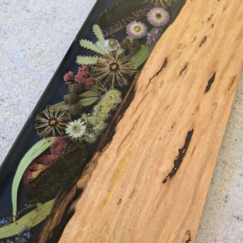 Discover the beauty of Australia’s landscapes in a functional piece of art with our unique cheese board. Made from locally sourced timber, resin, and dried Australian flora, each board is a testament to artisanal craftsmanship and the natural splendor of our continent. Designed to elevate your home decor, our cheese boards are not just serving essentials but exquisite pieces that showcase Australia’s stunning flora. Each board features carefully arranged dried native flora encased in translucent resin, creating a mesmerizing display of colors and textures. Whether displayed on your kitchen counter or used to serve guests, it becomes a focal point that sparks conversation and admiration.