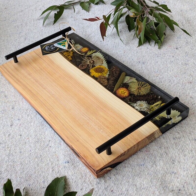 Celebrate Australia with our handcrafted serving platter. Made from locally sourced timber, resin, and dried Australian flora, it serves as a functional cheese board and a showcase of Australia’s beauty. Perfect for gifting, each board blends native timber with translucent resin and preserved flora, capturing the essence of our landscapes. Presented in elegant packaging, it’s a thoughtful gift ready for worldwide shipping.