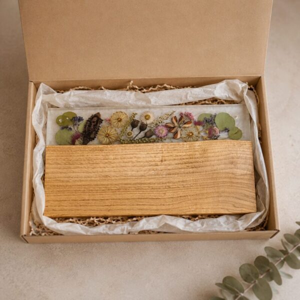 Australian timber and botanical resin serving board presented inside an open kraft gift box with tissue and protective paper.